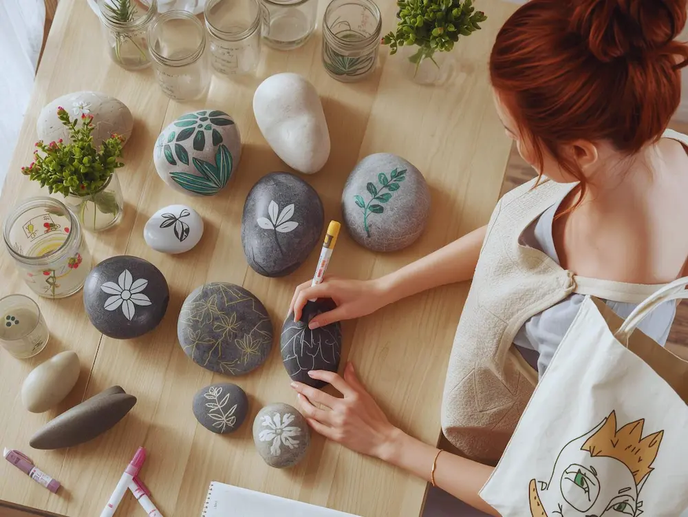 Feutres Posca utilisés pour décorer des galets avec des motifs colorés dans un atelier DIY lumineux